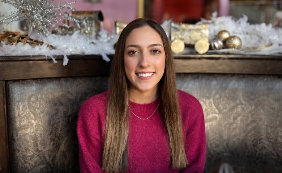 Hailey Steffensen smiling warmly, seated in a restaurant booth